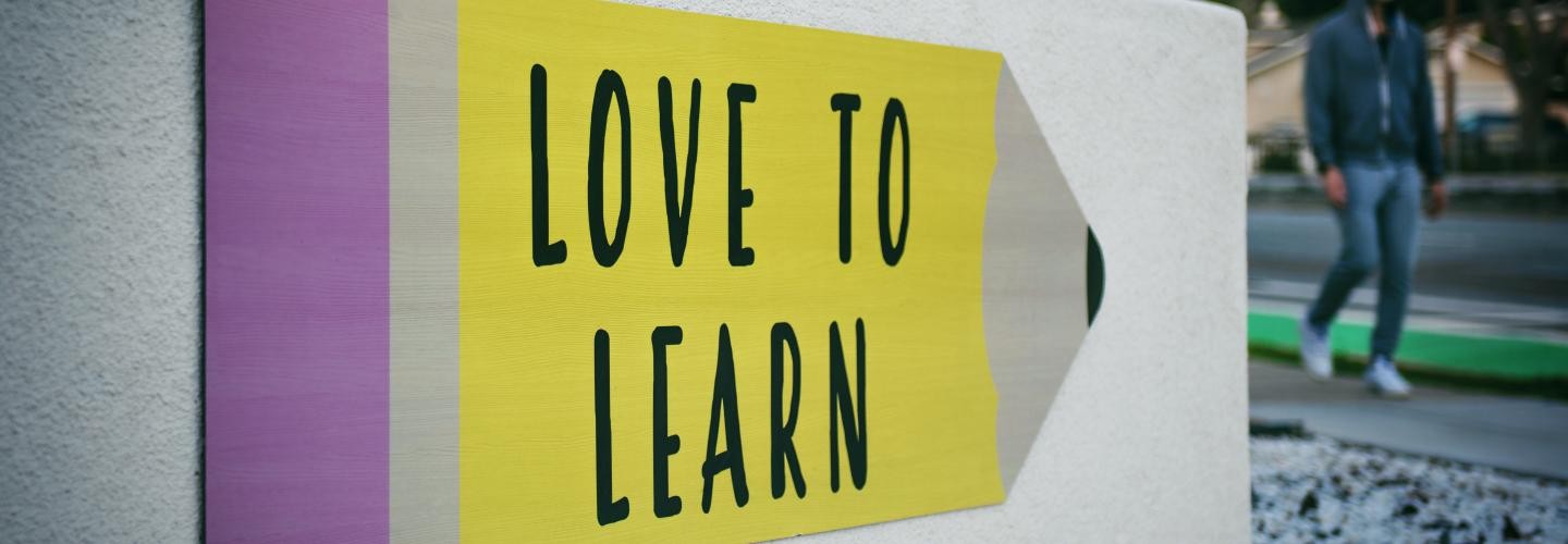 Schild in Bleistiftform mit der Aufschrift "love to learn"