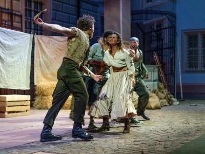 Eine Personengruppe gerät in Streit; Szene vom Musical Der Mann von La Mancha im Schlosshof