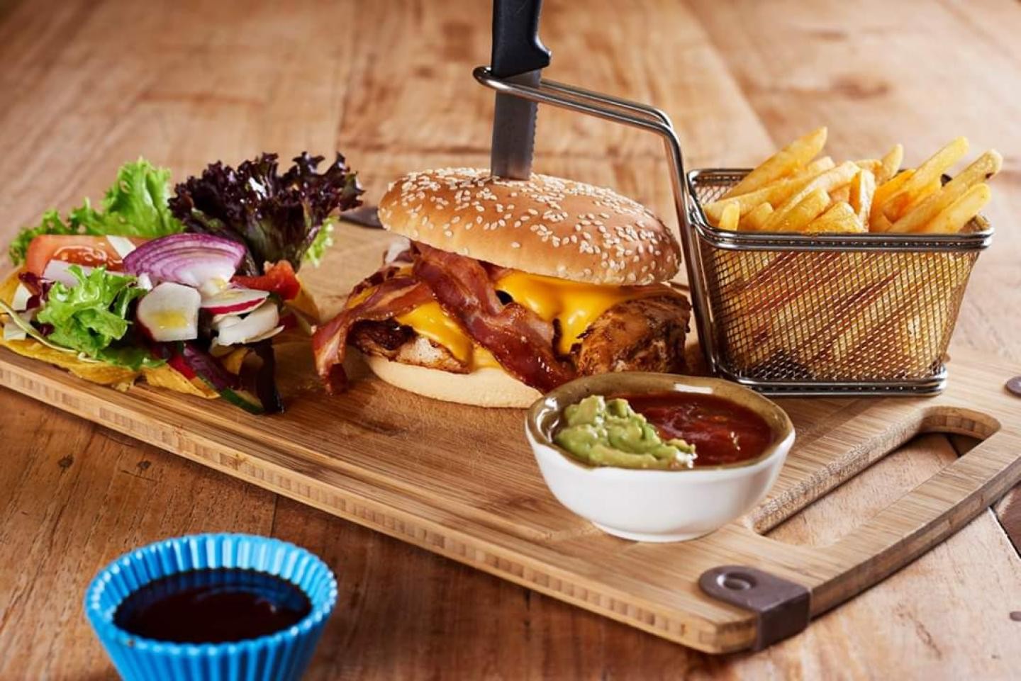 Ein Vesperbrett mit Burger, Pommes und Salat