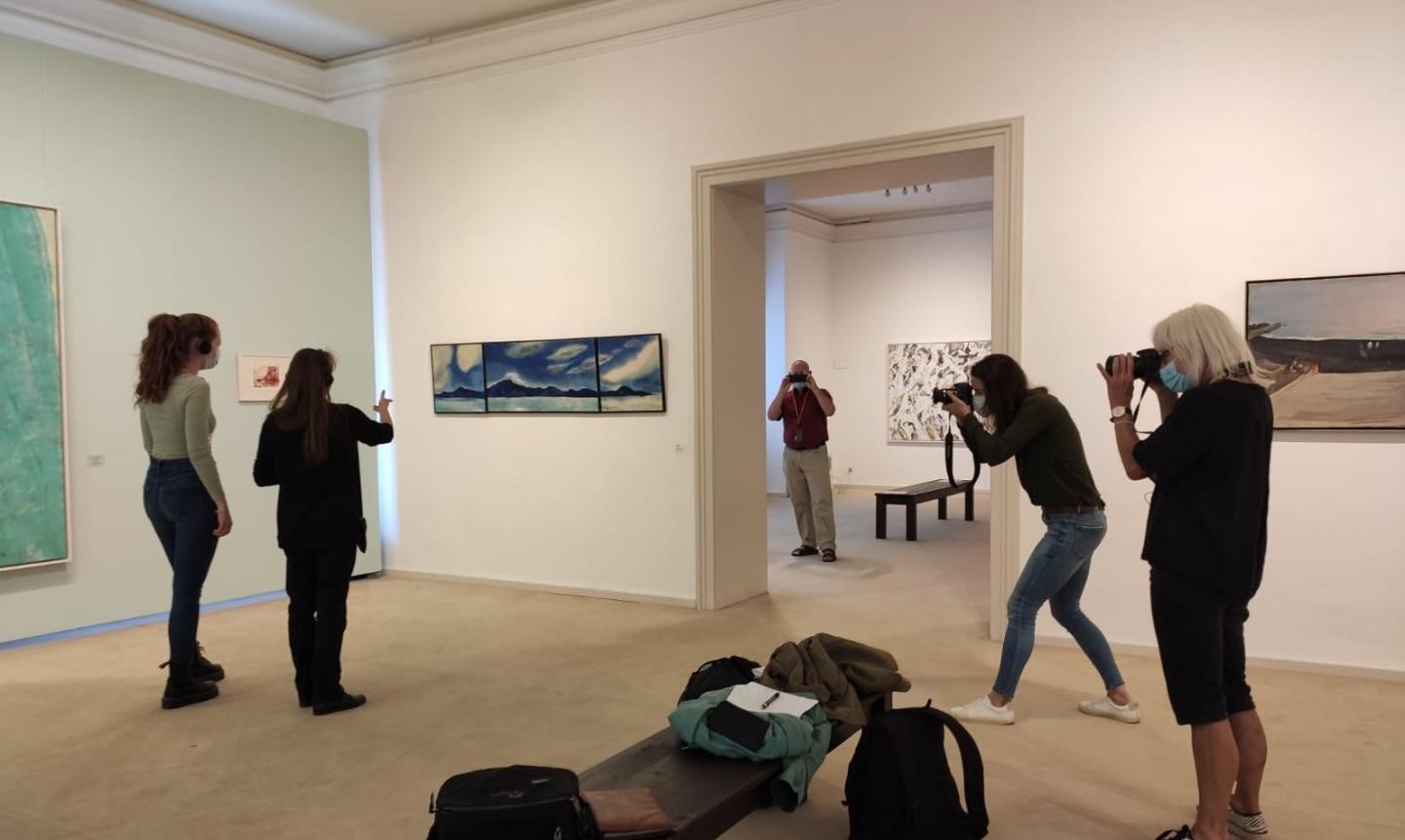 drei Fotografen und zwei Besucherinnen in Ausstellung