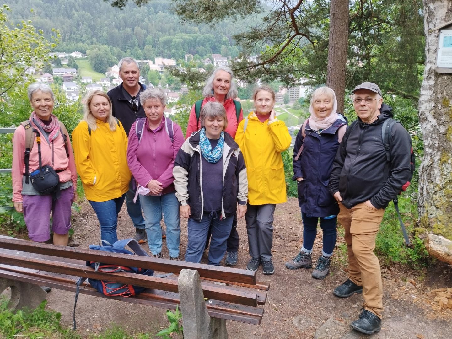 Gruppe von Wandernden blicken in die Kamera, im Hintergrund schöne Aussicht