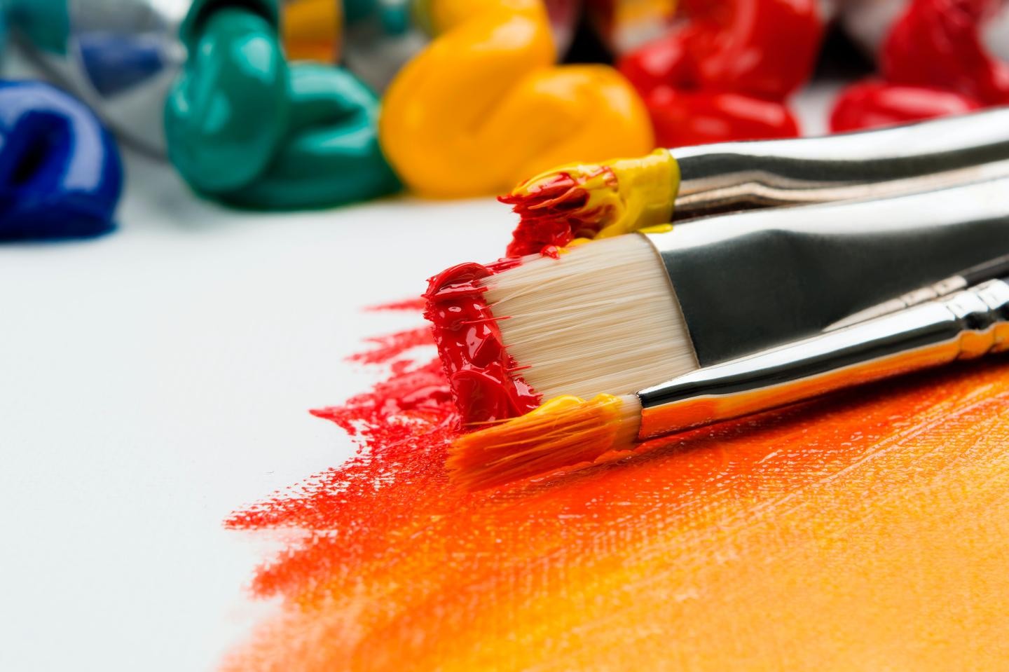 Farbpinsel mit Acrylfarben im Hintergrund