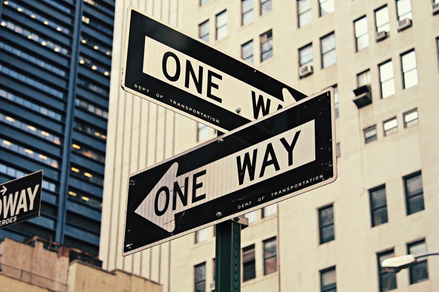 Zwei Straßenschilder mit der Aufschrift "one way" zeigen in unterschiedliche Richtungen