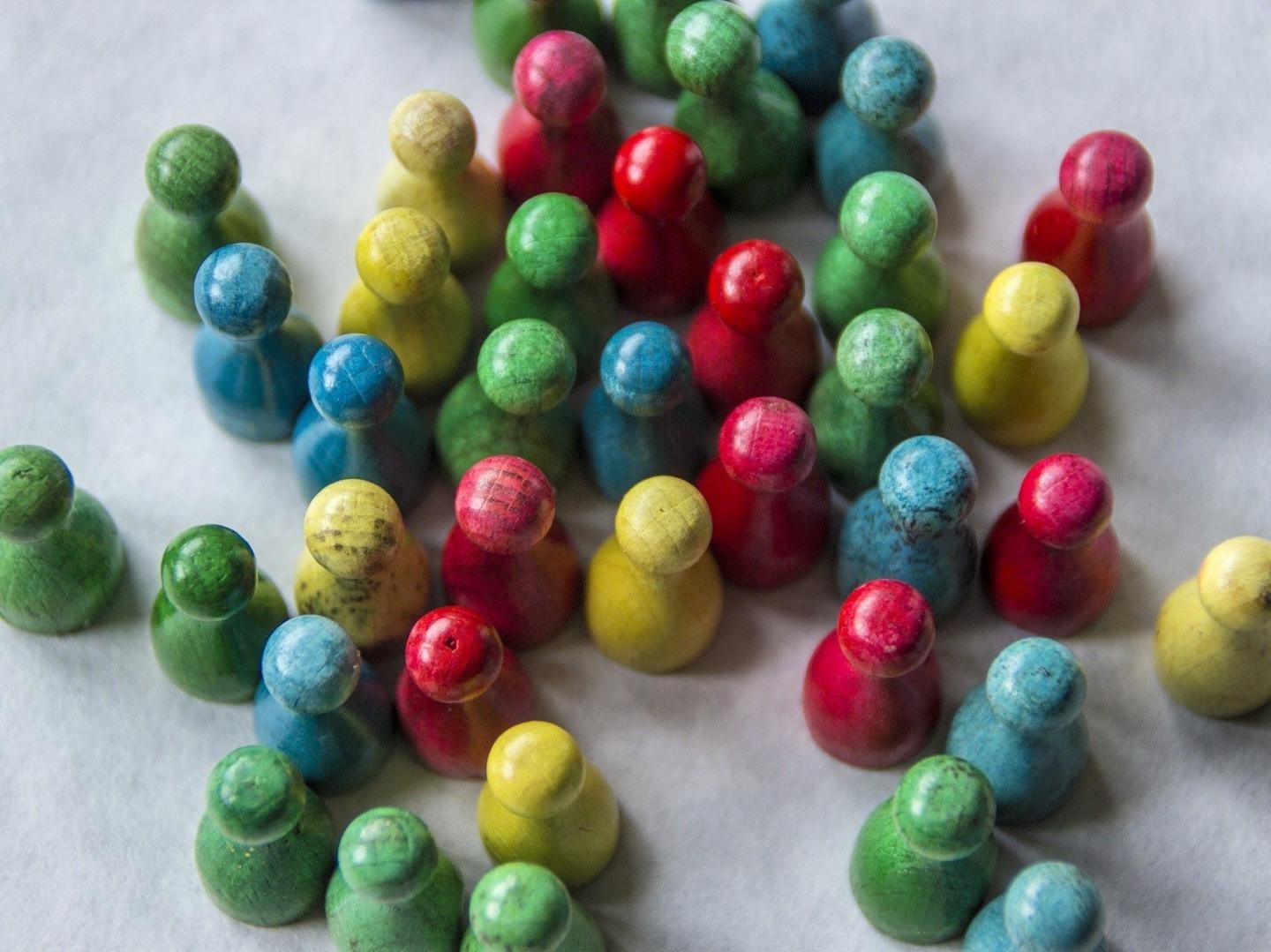 viele Spielfiguren aus bunt lackiertem Holz