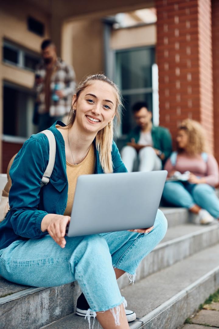 Junge Frau einer Treppe sitzend mit Laptop