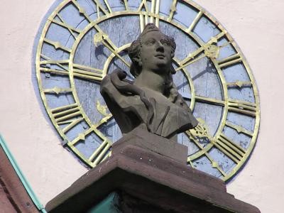 Büste am Rathaus, im Hintergrund eine Uhr
