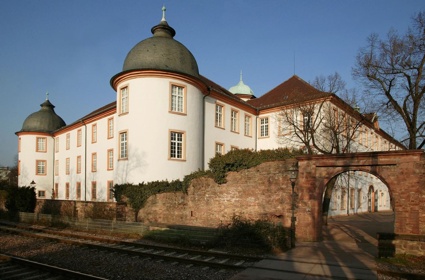 Außenansicht des Schloss Ettlingens am Tag von Bahnübergang aus 