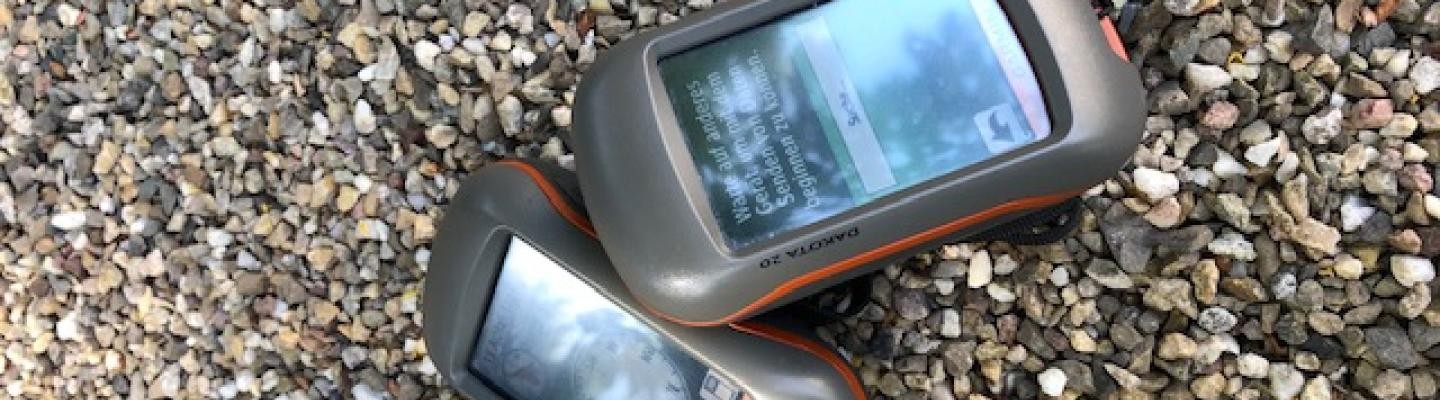 Zwei GPS-Geräte auf Kieselsteinen Zwei GPS-Geräte auf Kieselsteinen