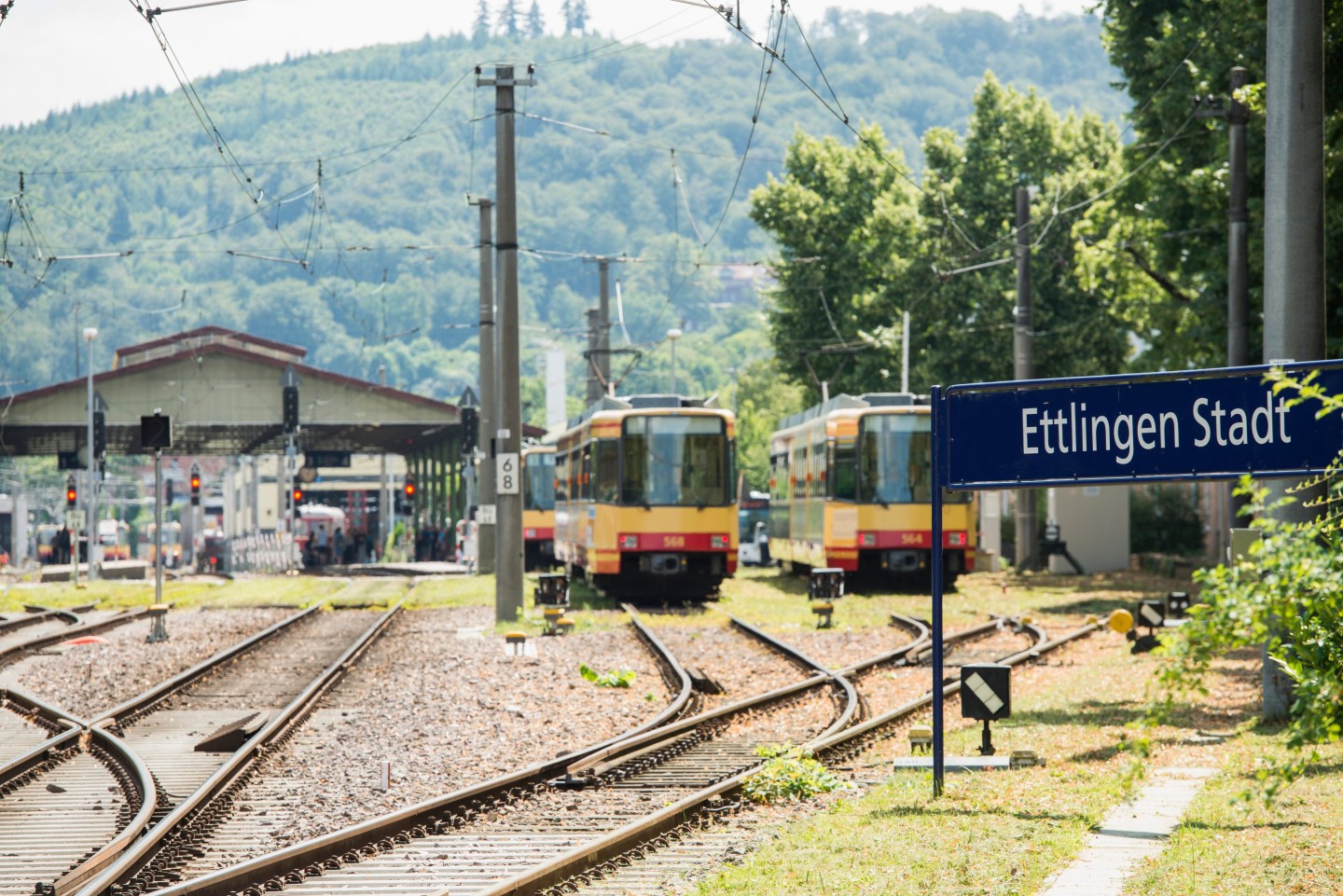 Auf den Gleisen steht eine gelbe Stadtbahn der Karlsruher-Verkehrsverbundes