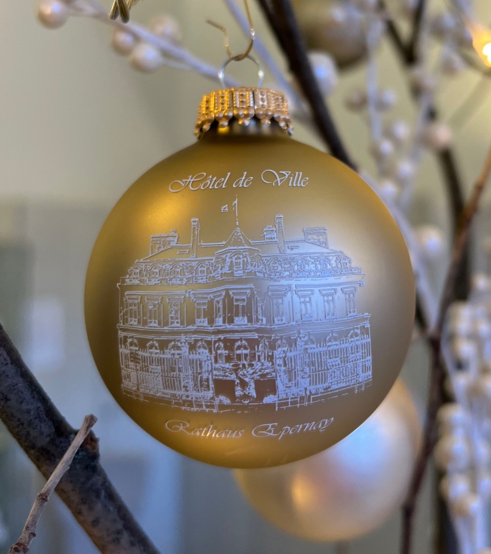 Zu sehen ist die Weihnachtskugel Edition 2022, champagnerfarben und mit der Abbildung des Rathauses in Epernay