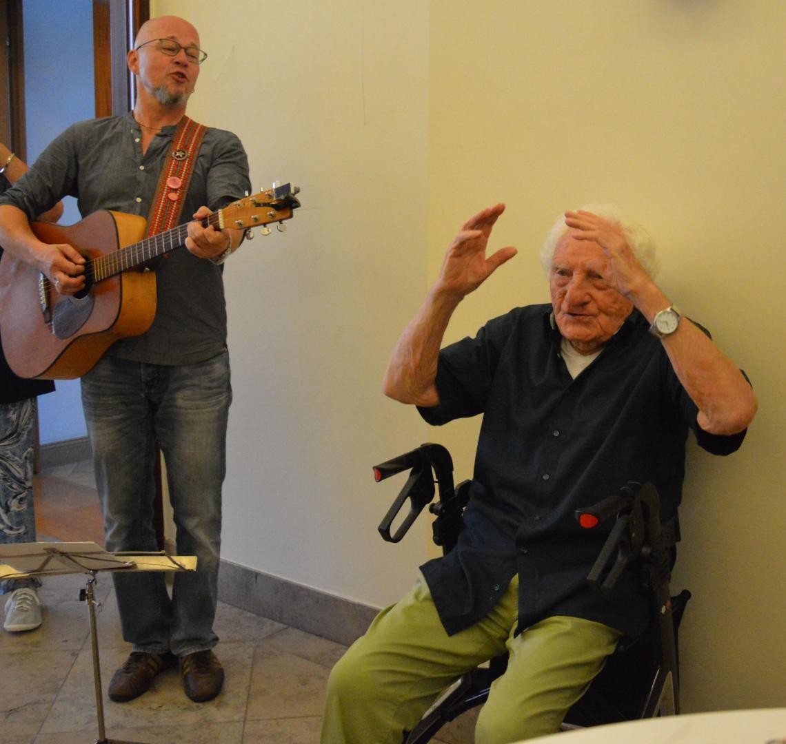 Der Jubilar singend, begleitet von einem Gitarristen. 