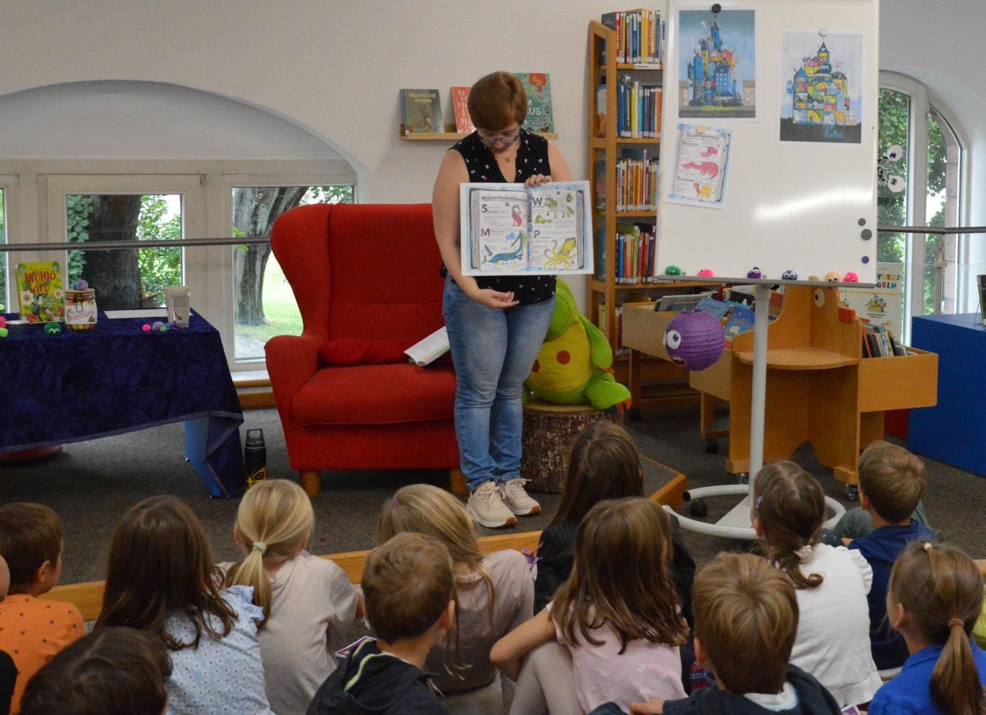 Man sieht Bibliotheksmitarbeiterin Bettina Haberstroh, wie sie das Buch zeigt. 