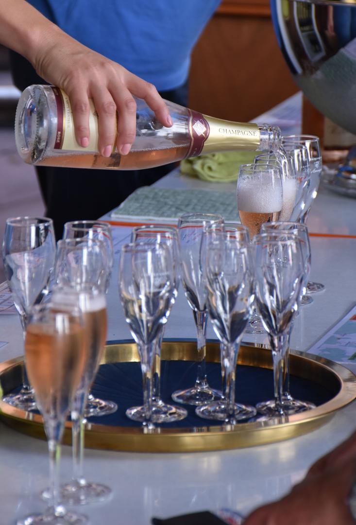 Ein Mann schenkt Rose-Champagner aus.