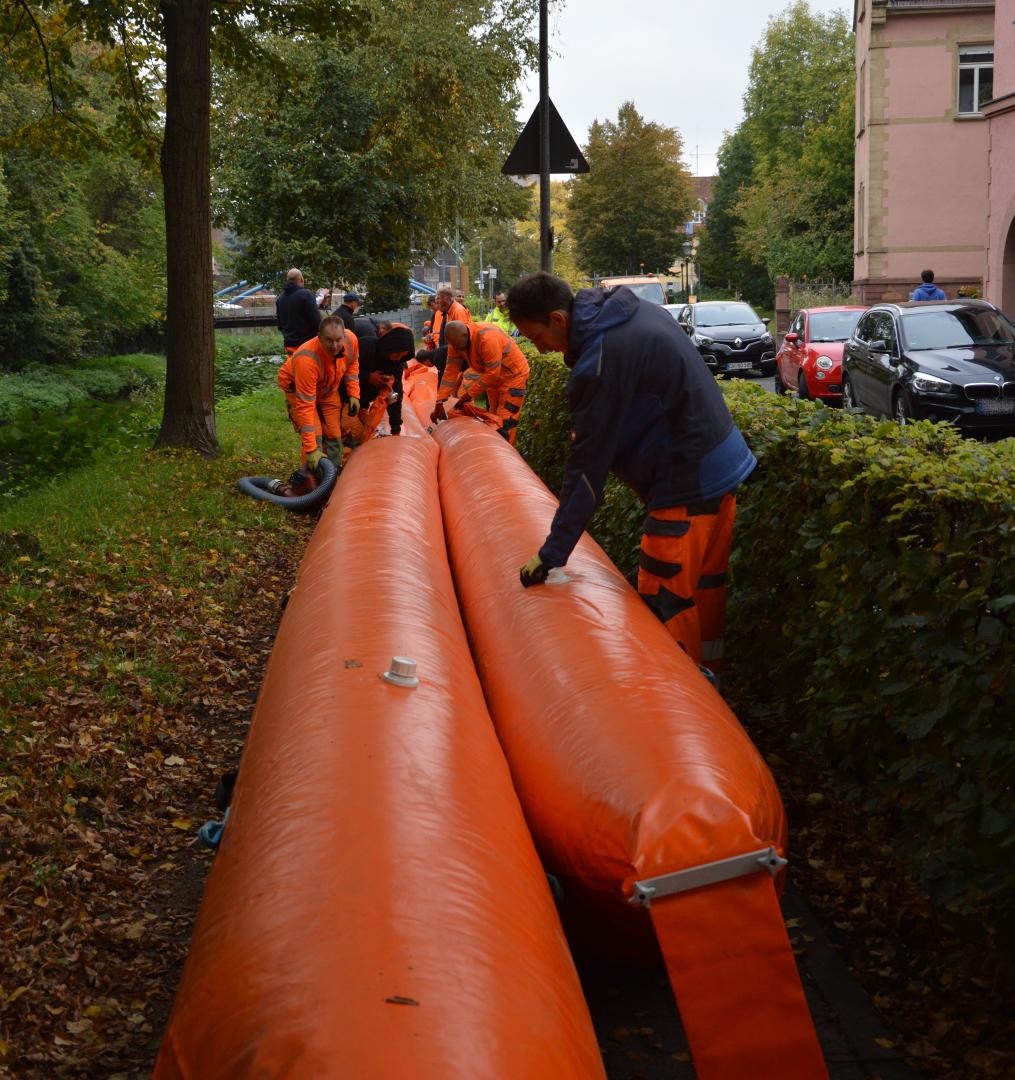 Die Mitarbeiter des Baubetriebshofes arbeiten am mobilen Hochwasserschlauch. 