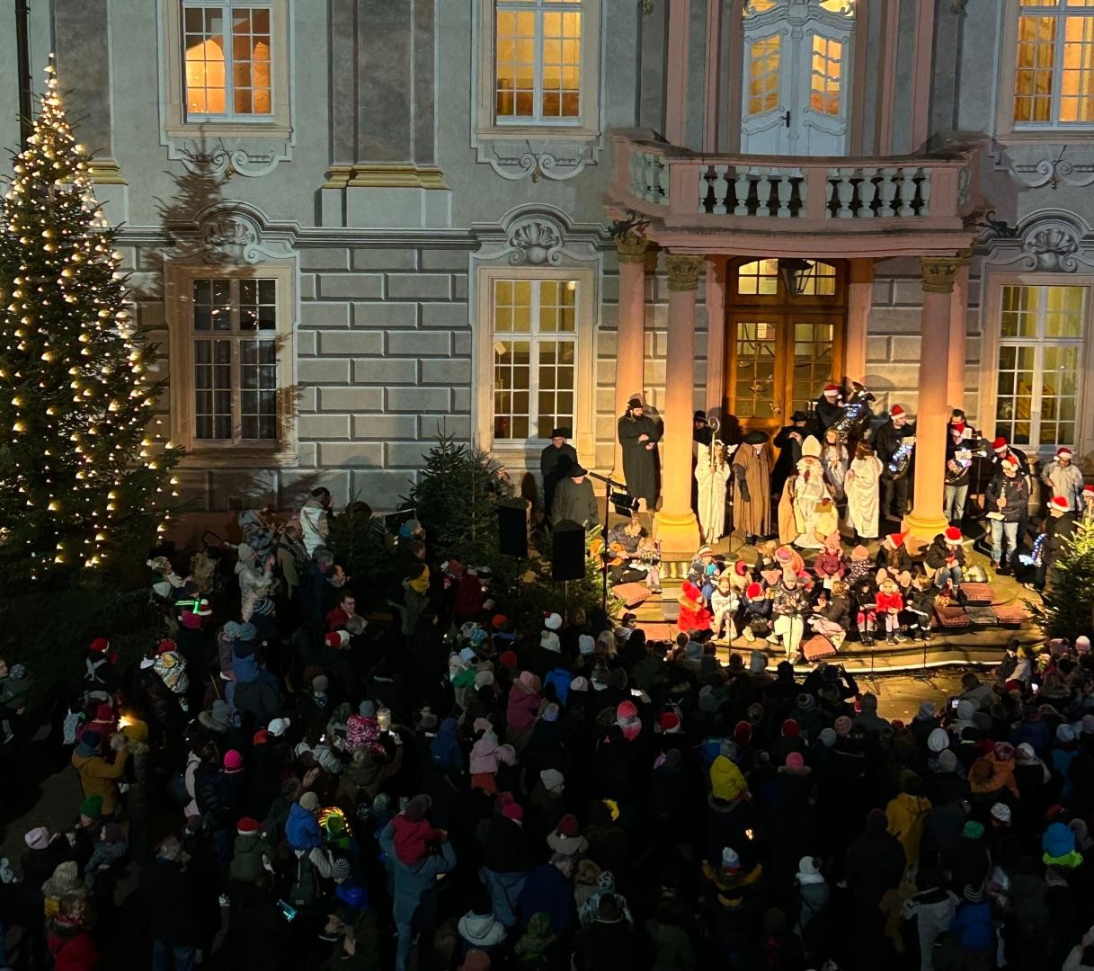 Hell illuminierter Schlosseingang mit dem Nikolaus und vielen Menschen