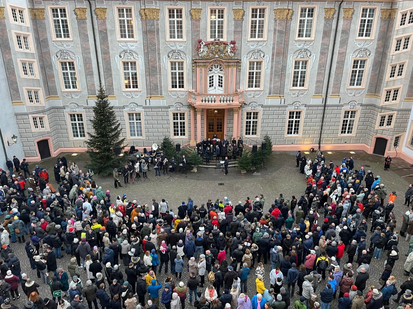 Im Schlosshof stehen Menschenmassen vor dem Eingang und lauschen den Weihnachtsgeschichten. 