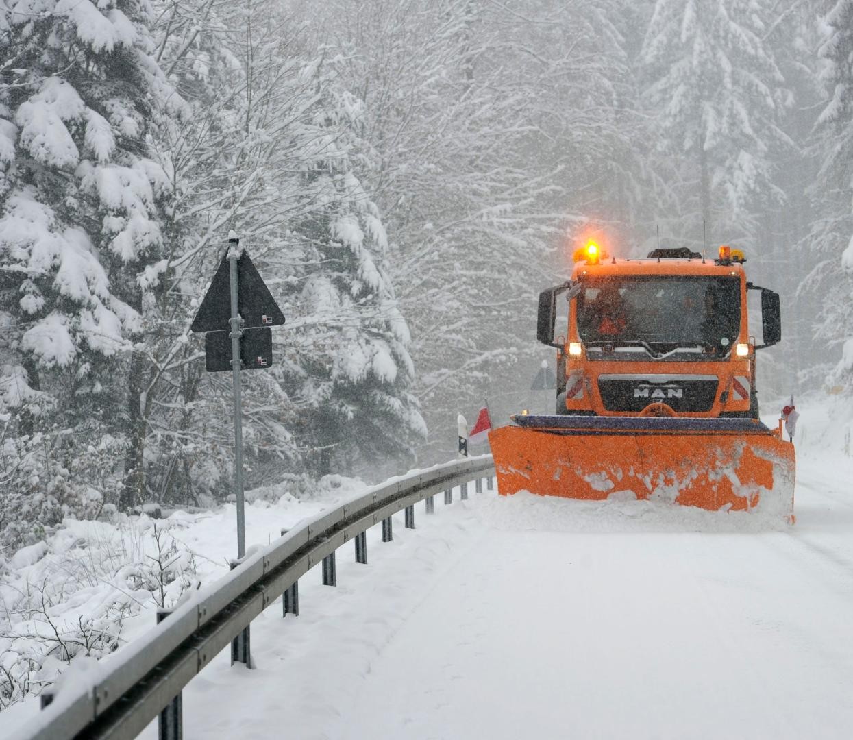 Schneepflug auf verschneiter Straße