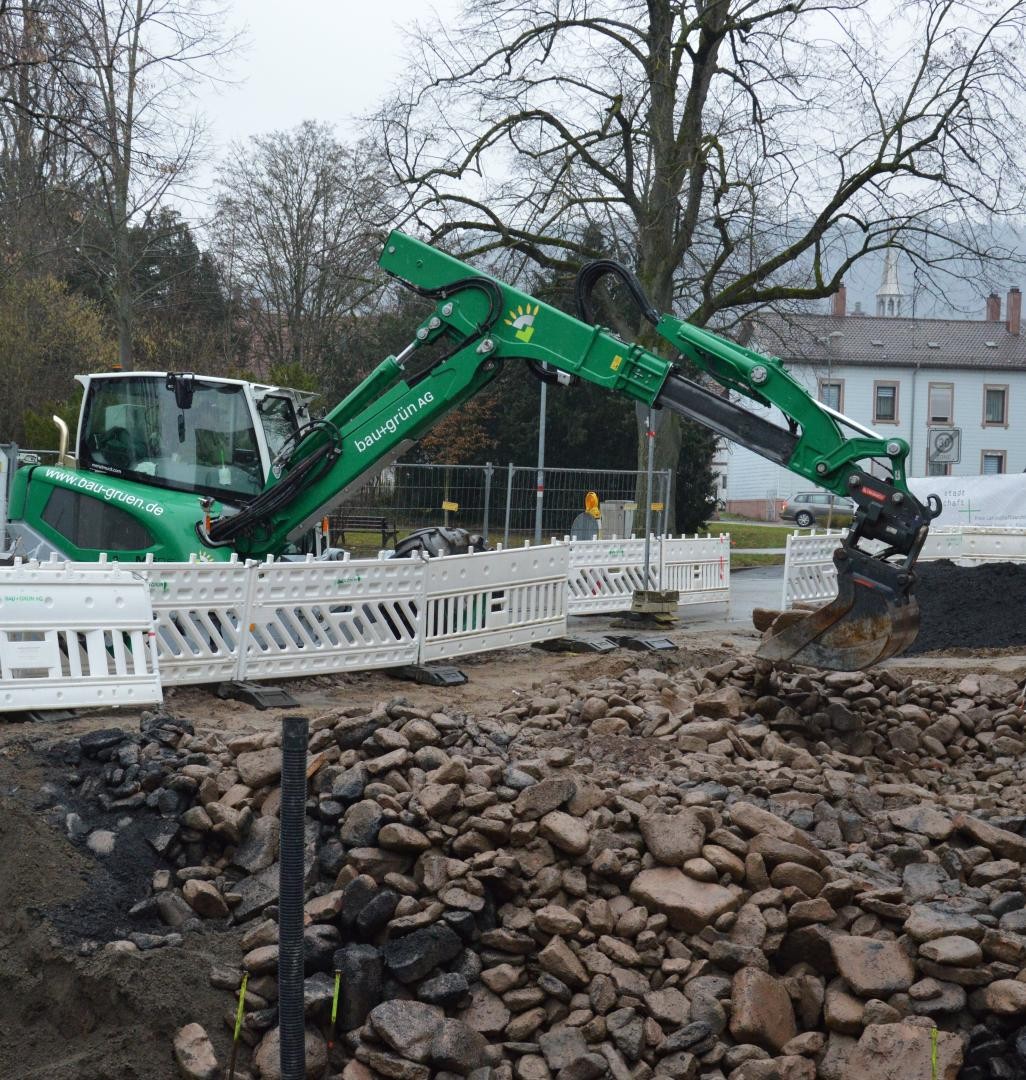 Mit einer Baggerschaufel wird das Albgeröll zu der künftigen Baumgrube gebracht.