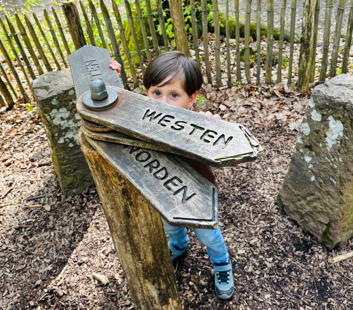 Ein Bub an einer Spindel, an der sich die Himmelsrichtungen einstellen lassen.