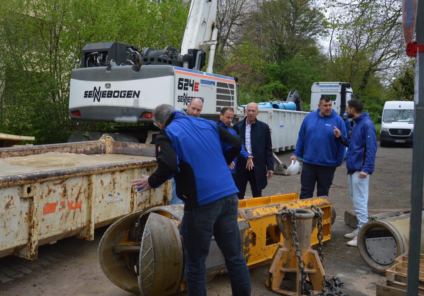Stefan Blüm zeigt auf einen Bohrkopf und im Hintergrund weitere Mitarbeiter der Stadtwerke