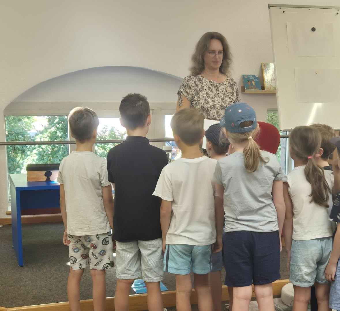 Bibliotheksmitarbeiterin Regina Jäkel erzählt Kinder beim Vorlesesommer eine Geschichte der Langohrhasenbande. 