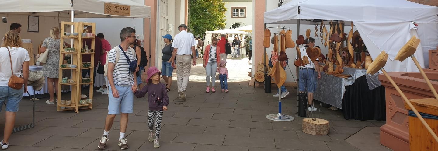 Stände von Kunsthandwerkern mit unterschiedlichen Besen und Keramiken im Schlosshof