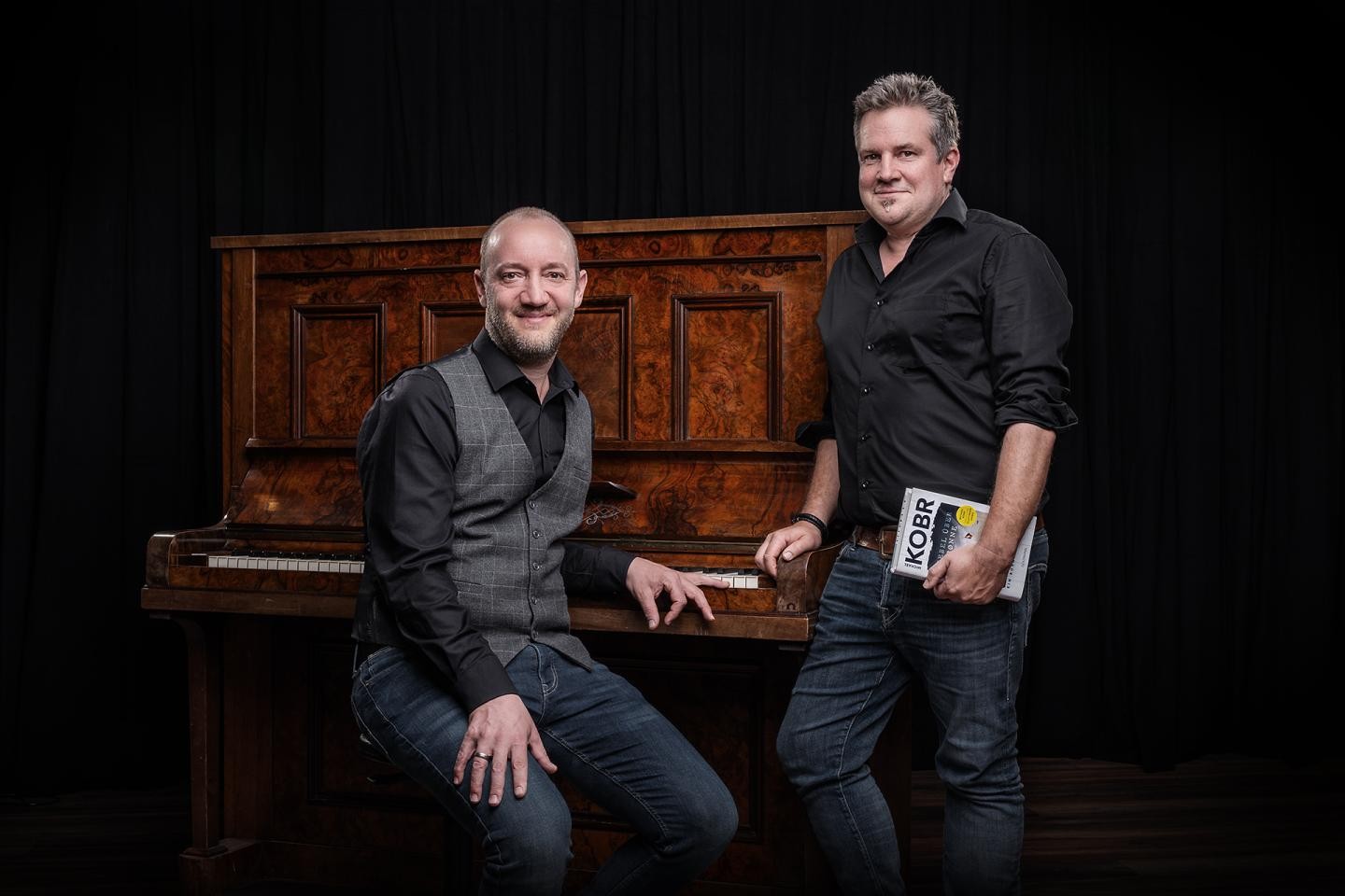Ein Autor mit einem Pianisten vor einem Klavier