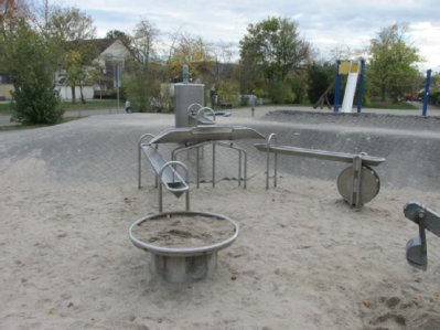 Wasserpumpenstelle mit Wasserablaufrinnen in Sandspielfläche