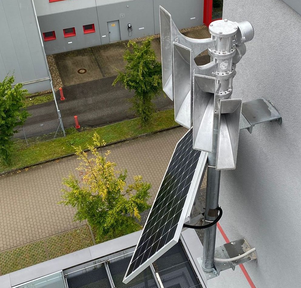 Blick von oben auf eine an einer Hauswand installierte Sirenenwarnanlage
