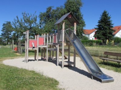 Klettergerät mit Rutsche auf Sandspielfläche