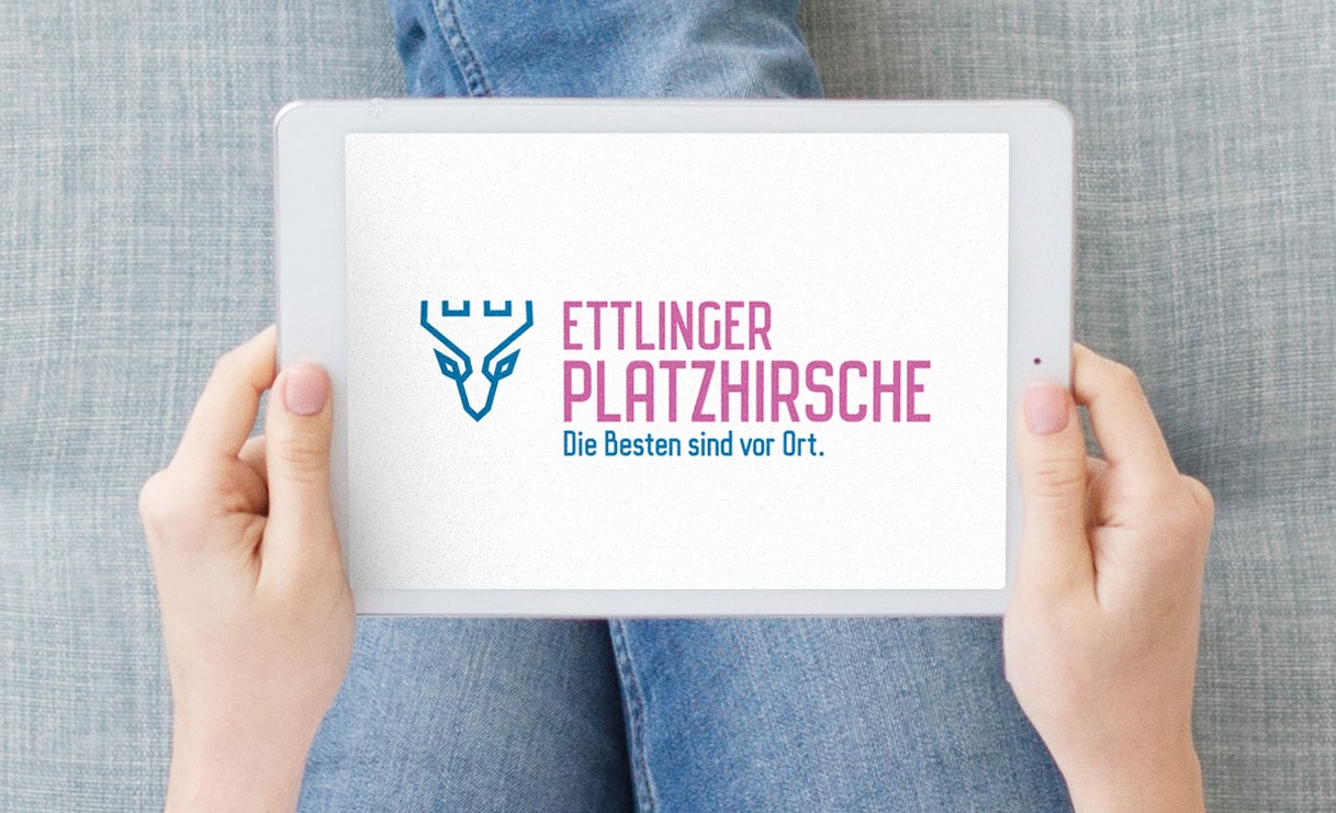 Foto eines Tablets in den Händen einer auf dem Sofa sitzenden Person