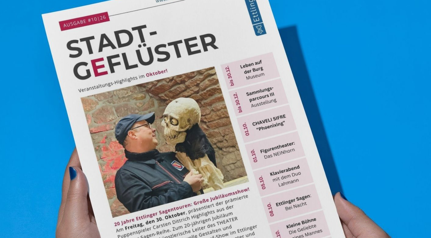 Eine Person hält eine Zeitung in der Hand auf der Stadtgeflüster steht