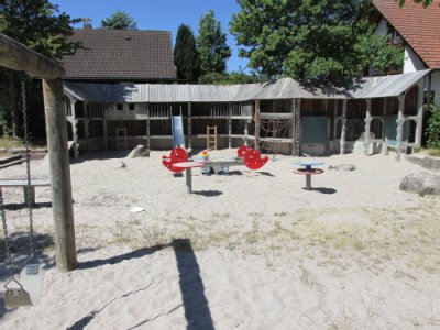 Wipptiere auf Sandspielfläche vor Klettergerät