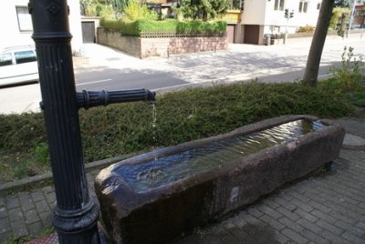 Rechteckiger Brunnentrog mit gußeiserner Säule mit Wasserauslauf