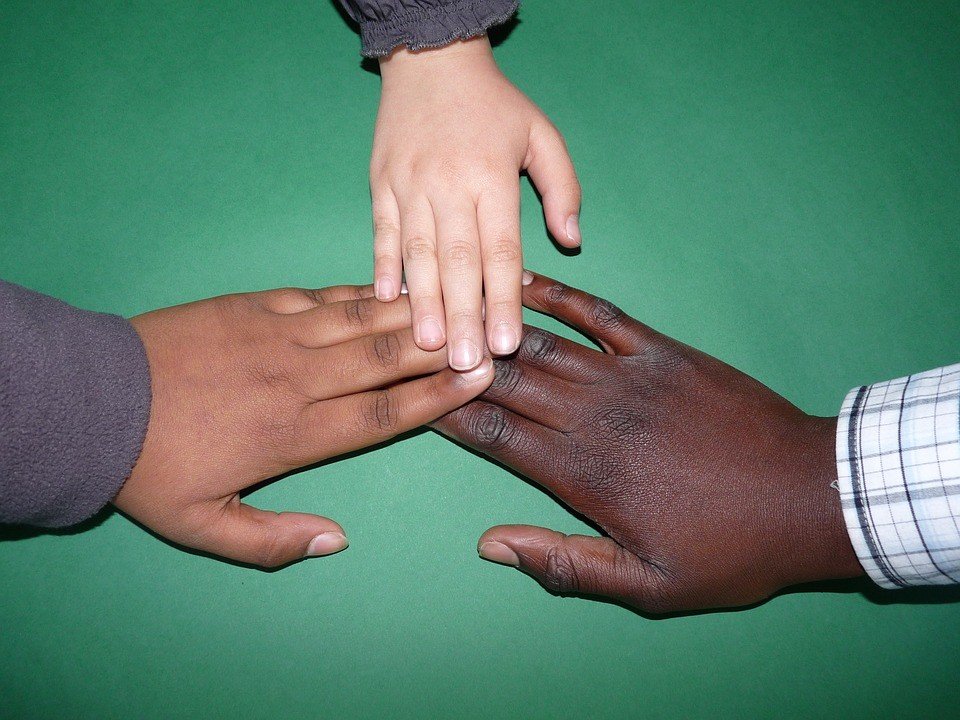 Drei Hände mit unterschiedlicher Hautfarbe 