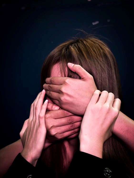 Gesicht eine Frau wird von Händen verdeckt